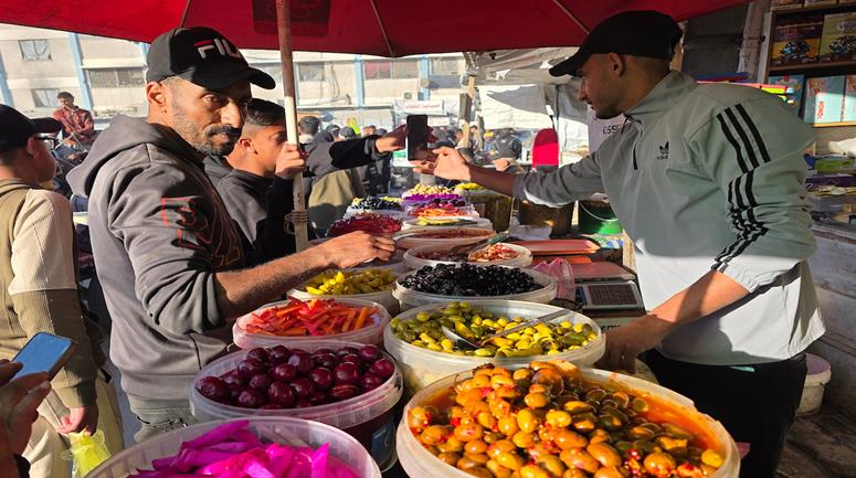 نازحون يتسوقون قبل الإفطار في سوق شعبي مؤقت في خان يونس جنوب قطاع غزة.