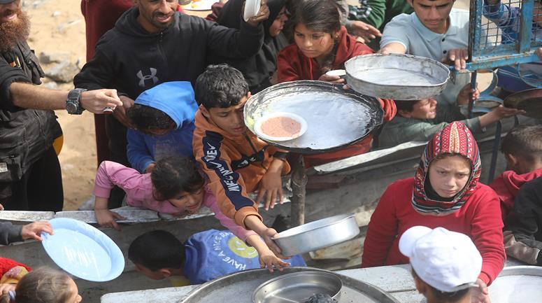 نازحون يتجمعون للحصول على وجبات طعام من تكية خيرية خلال شهر رمضان في مدينة غزة