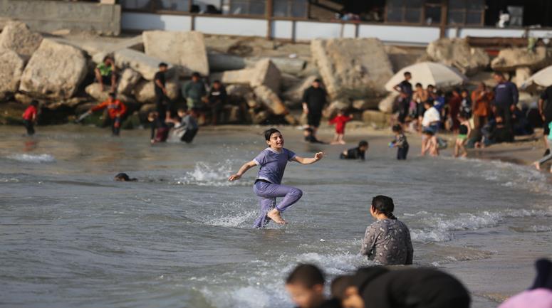 نازحون يلجؤون إلى شاطئ غزة كمأوى ومتنفس بعد تدمير منازلهم بفعل الحرب.
