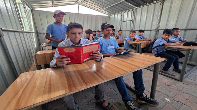 طلبة يبدأون عامهم الدراسي الجديد داخل خيام وغرف من الصفيح في مدينة خان يونس جنوبي قطاع غزة، وسط أضرار واسعة لحقت بالمدارس ونقص في المرافق التعليمية جراء الحرب