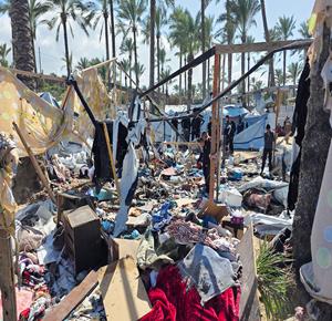 مواطنون يتفقدن الدمار بخيام النازحين بعد استهداف الاحتلال لخيمة تأوي نازحين في مواصي خان يونس