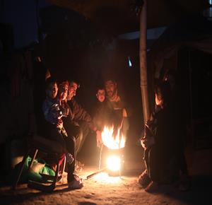 نازحون في الخيام يشعلون النار للتدفئة والطهي وسط انقطاع الكهرباء في مخيم النصيرات وسط قطاع غزة