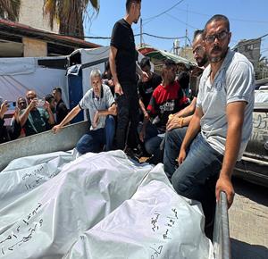 مواطنون يودعون جثامين الشهداء عمر أبو قاسم وزوجته وطفلتهم بعد استشهادهم في غارة إسرائيلية استهدفت شقتهم في دير البلح وسط قطاع غزة