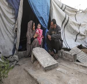 النازح خالد الزعانين يعيش مع أسرته في ظروف غير إنسانية في خيمة داخل مقبرة بدير البلح وسط قطاع غزة، بعد نزوحه من بيت حانون