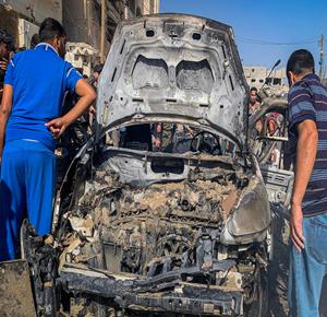 مواطنون يتجمعون في موقع غارة جوية إسرائيلية استهدفت مركبة في حي تل الهوى جنوب غرب مدينة غزة