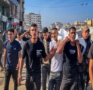  مواطنون يشيعون جثماني شهيدين في مدينة غزة، بعد استشهادهما في غارة جوية إسرائيلية استهدفت مركبة في حي تل الهوى