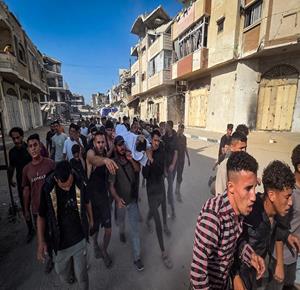 مواطنون يشييعون جثمان شهيد بمدينة خان يونس جنوب قطاع غزة، بعد استشهاده جراء غارة إسرائيلية استهدفت سطح مدرسة تؤوي نازحين