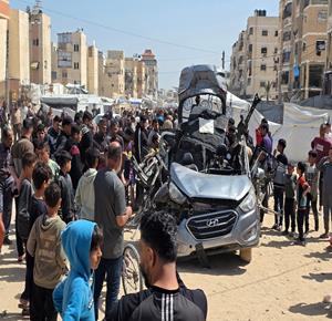 مواطنون يتفقدون مركبة قصفها الاحتلال الاسرائيلي في خان يونس جنوب قطاع غزة