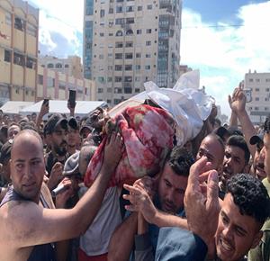 مواطنون ينقلون جثمان شهيد بعد استهدافه من قبل طائرات الاحتلال الإسرائيلي غربي مدينة غزة