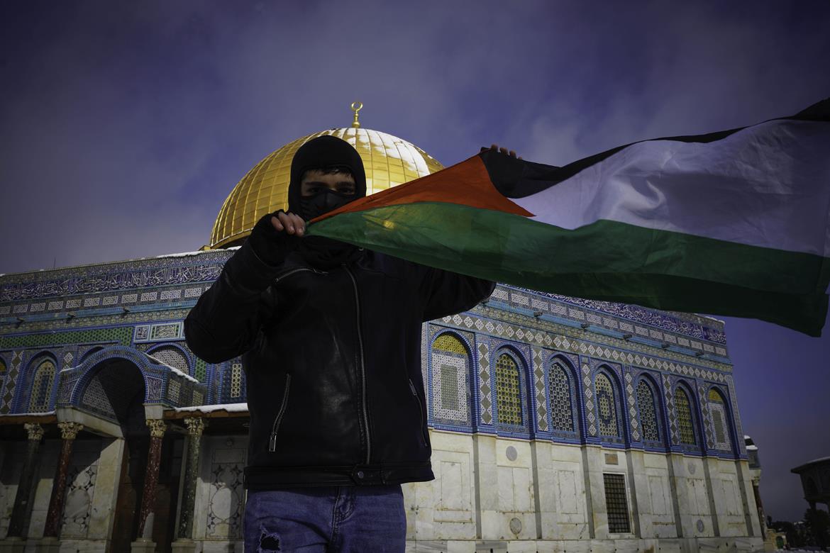 طفل يرفع العلم الفلسطيني في باحات المسجد الأقصى المبارك بالقدس المحتلة (عدسة: عفيف عميرة/وفا)