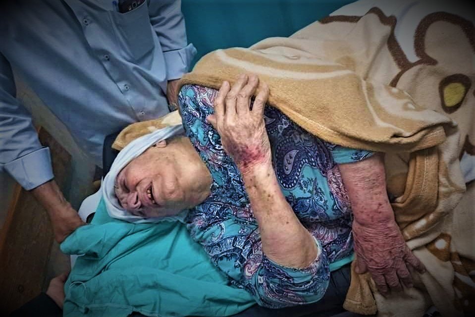 "أم جبر وشاح" على سرير الشفاء في مستشفى شهداء الأقصى عقب اعتداء ميلشيا حماس عليها