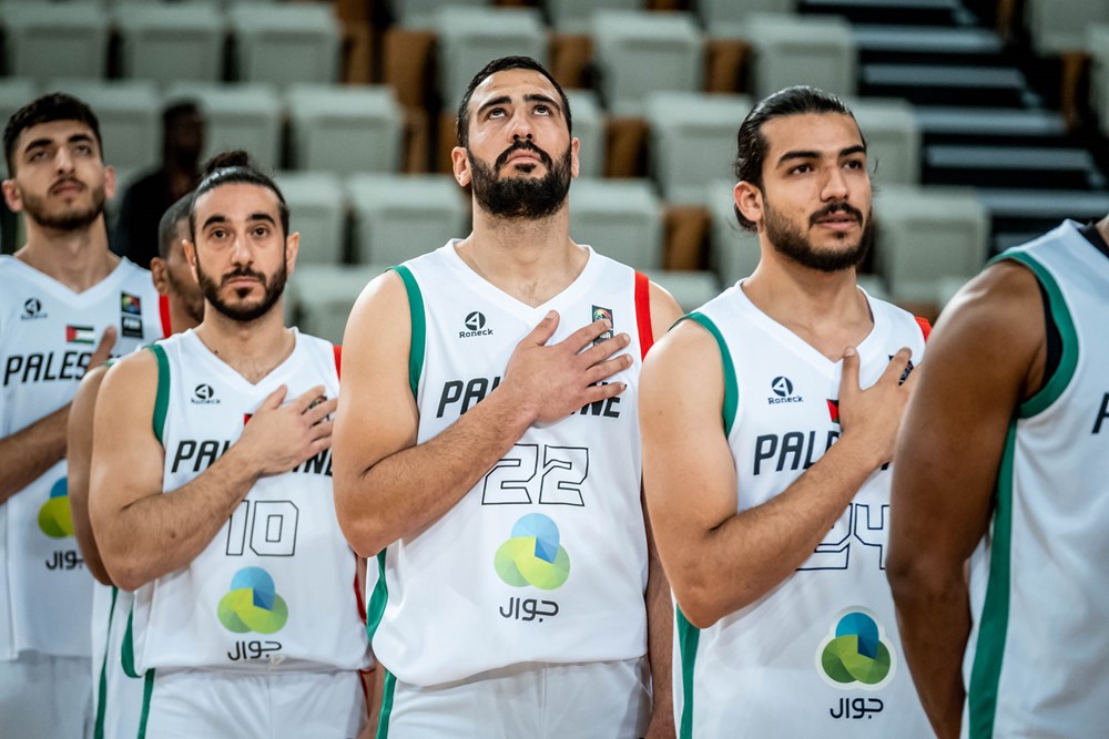 "فدائي" السلة خلال عزف النشيد الوطني الفلسطيني قبل انطلاق المباراة مع شقيقه الإماراتي