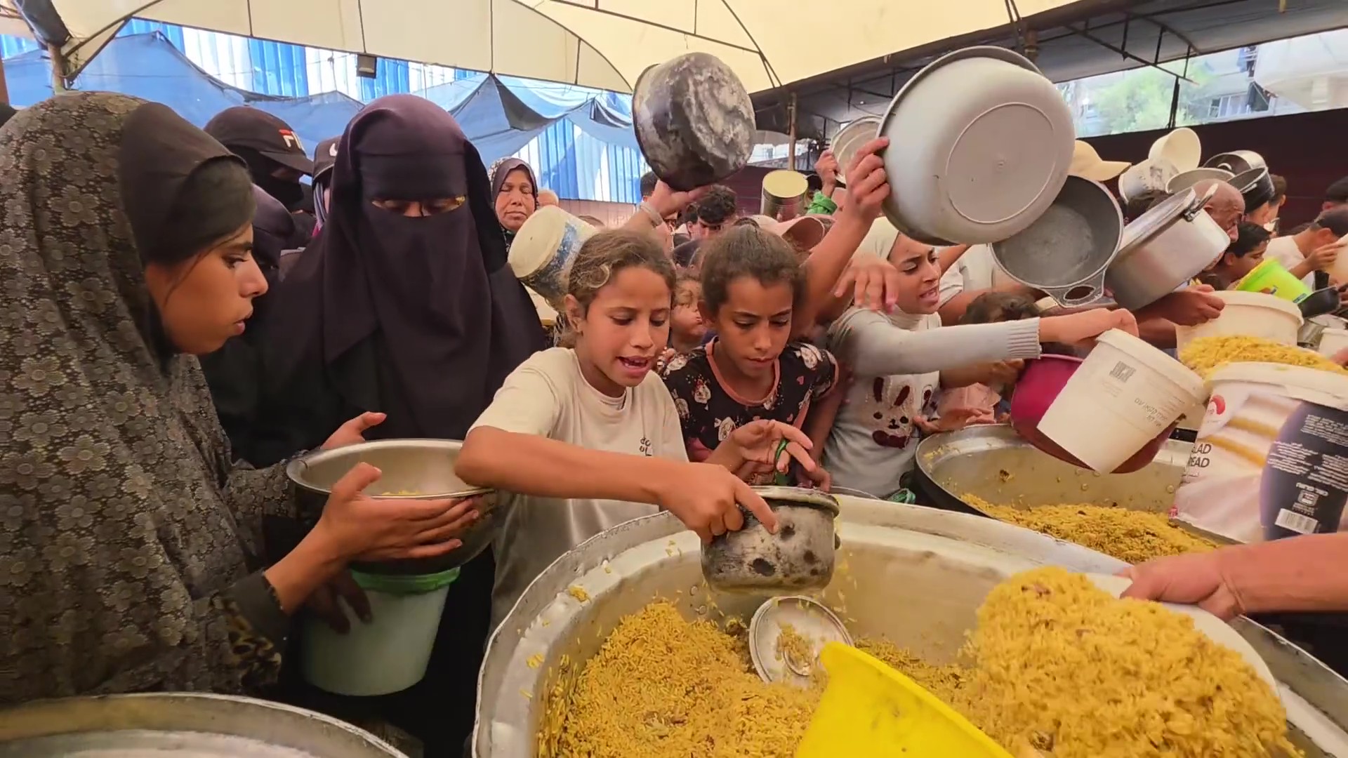 تزاحم للحصول على طعام في مخيم النصيرات بغزة تزاحم للحصول على طعام في مخيم النصيرات بغزة
