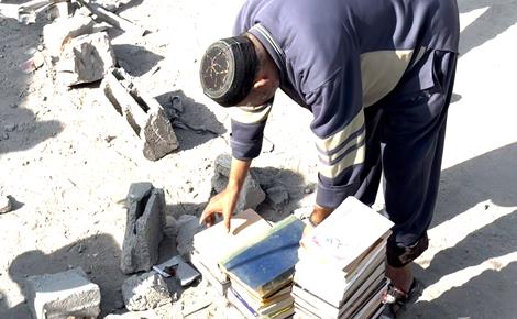 الدلو يبحث بين الركام عن بقايا مكتبته في غزة