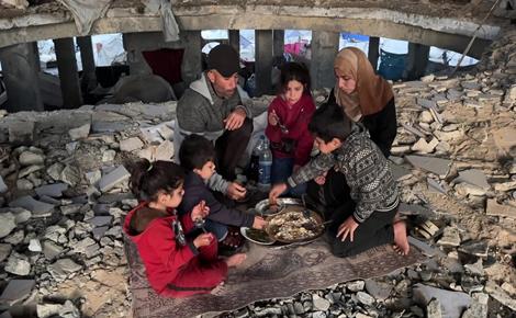 أسرة نازحة تتناول إفطار رمضان على أنقاض مسجد بغزة 